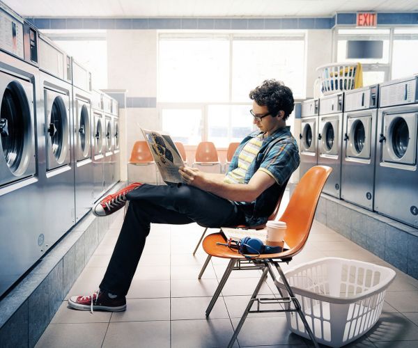 mark luinenburg photography of man sitting in laundromat