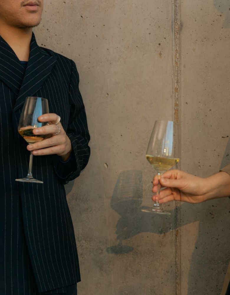 Two people turned towards each other in conversation holding wine glasses